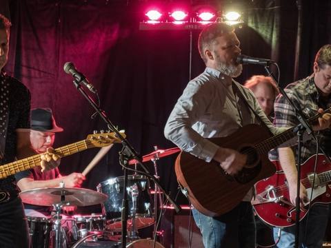 The Threads performing at The Leaf Bar and Grill under red lighting with full band