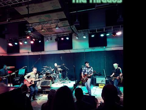 Wide stage shot of The Threads performing at a large venue with production lighting